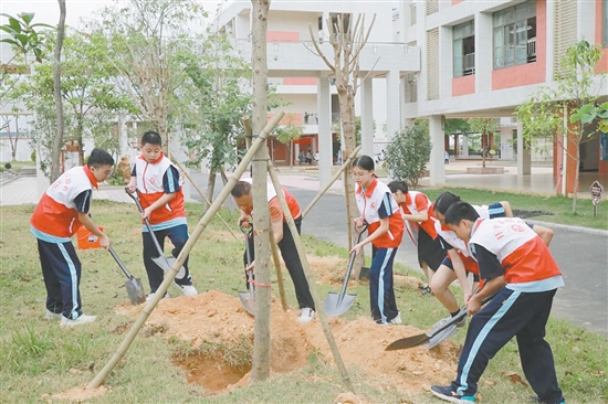 港澳鄉(xiāng)親與學(xué)生們一起植樹，美化校園環(huán)境。