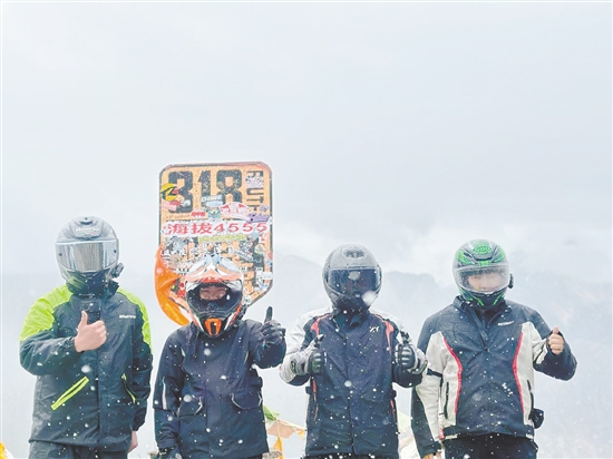 余鴻威（右一）與“旅游搭子”騎摩托車(chē)到西藏途中合影留念。