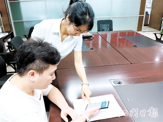 工作人員在指導(dǎo)市民線上交存住宅專項(xiàng)維修資金。陸沿任