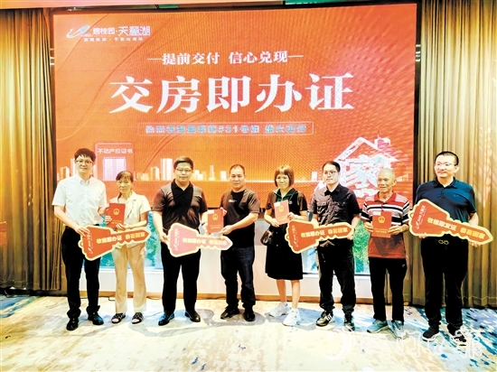 業(yè)主喜拿房產(chǎn)證和鑰匙。