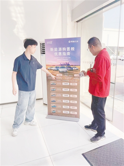 銷售人員向市民介紹優(yōu)惠政策。